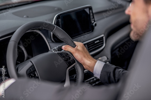 Close-up of male hands holding steering wheel