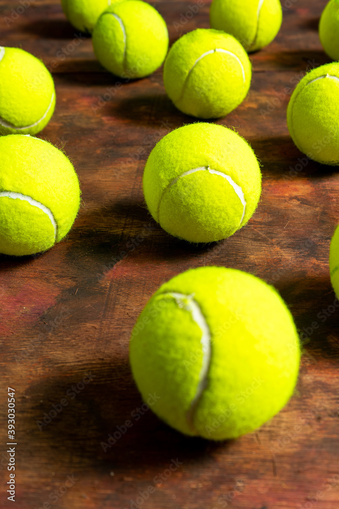 Tennis balls in composition on old wooden background in brown tones