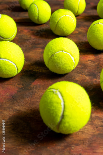 Tennis balls in composition on old wooden background in brown tones © Andres