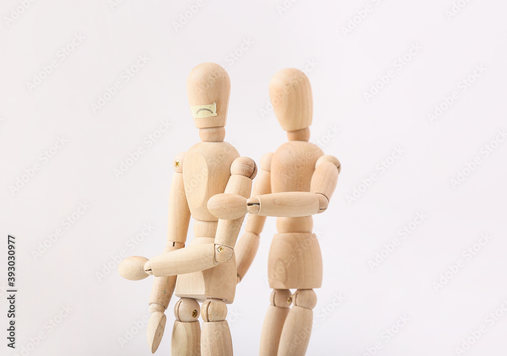 Wooden mannequins on light background. Concept of violence Wooden mannequins on light background. Concept of violence