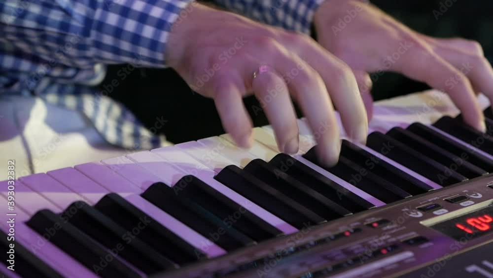 Big hands on the keys of the synthesizer. Big hands on the keys of the synthesizer.