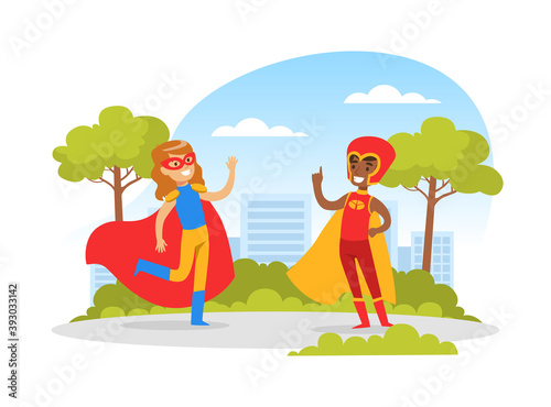 Cute Boy and Girl Dressed in Superhero Costumes Playing Outdoors, Happy Kids Having Fun in Park Cartoon Vector Illustration © topvectors