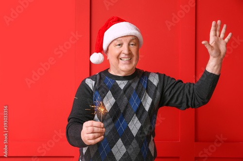 Senior man in Santa hat and...