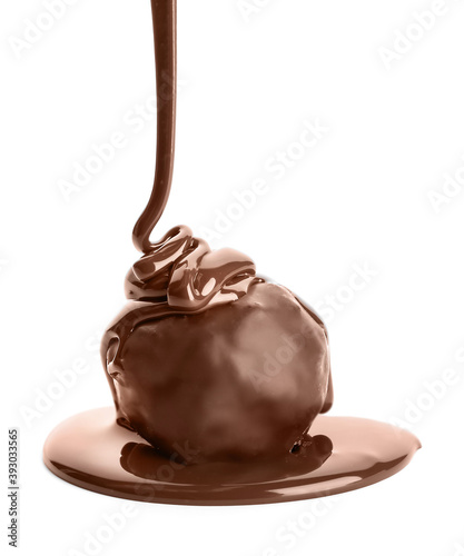 Pouring of melted chocolate on sweet candy against white background