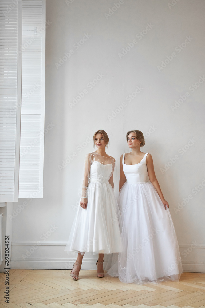 Two Beautiful slender woman in white wedding dress, new collection of dresses for the bride. Noise, out of focus