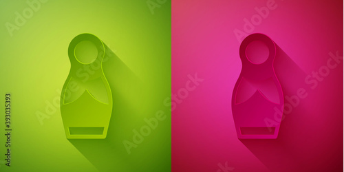 Paper cut Russian doll matryoshka icon isolated on green and pink background. Paper art style. Vector.