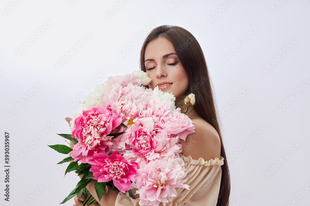 Beautiful woman with lots of pink flowers in her hands. Sexy woman with long hair