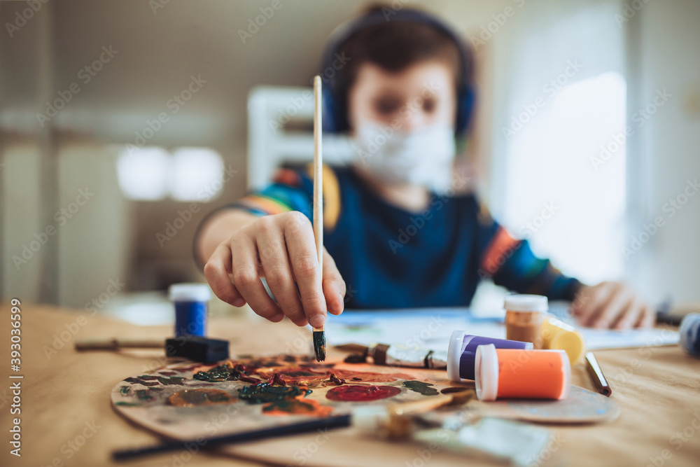 Fototapeta premium Cute little boy painting a picture in home studio