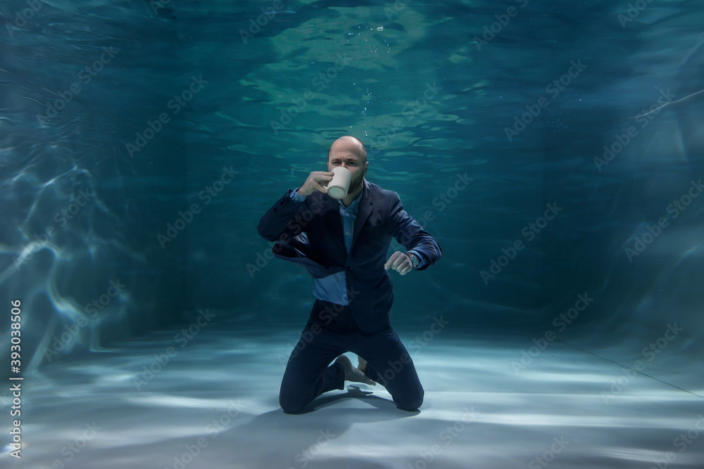 Young businessman drinking coffee in morning underwater. Emotional man with mug at bottom of pond, enjoying taste. Concept of working time making business decision at beginning of day. Copy space