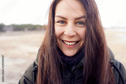 Happy smiling caucasian woman with dark hair in winter jacket © ln_a