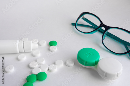 On a white background are items for improving vision, glasses, eye drops, pills and vitamins, contact lenses for improving vision. The concept of vision improvement