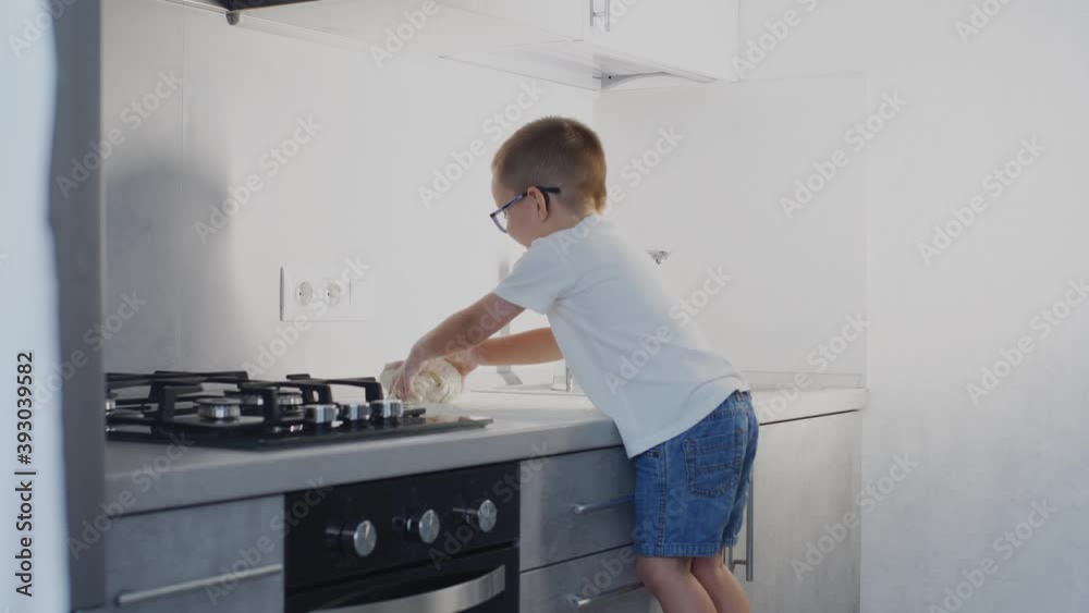 Little boy makes dough in the kitchen. Little boy makes dough in the kitchen.