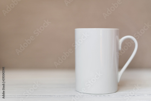 White cup, mug on white wooden background. Coffee or tea mockup