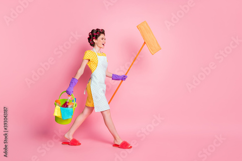 Full length profile side photo girl go hold mop bucket wear dotted dress slippers rubber gloves isolated pastel color background