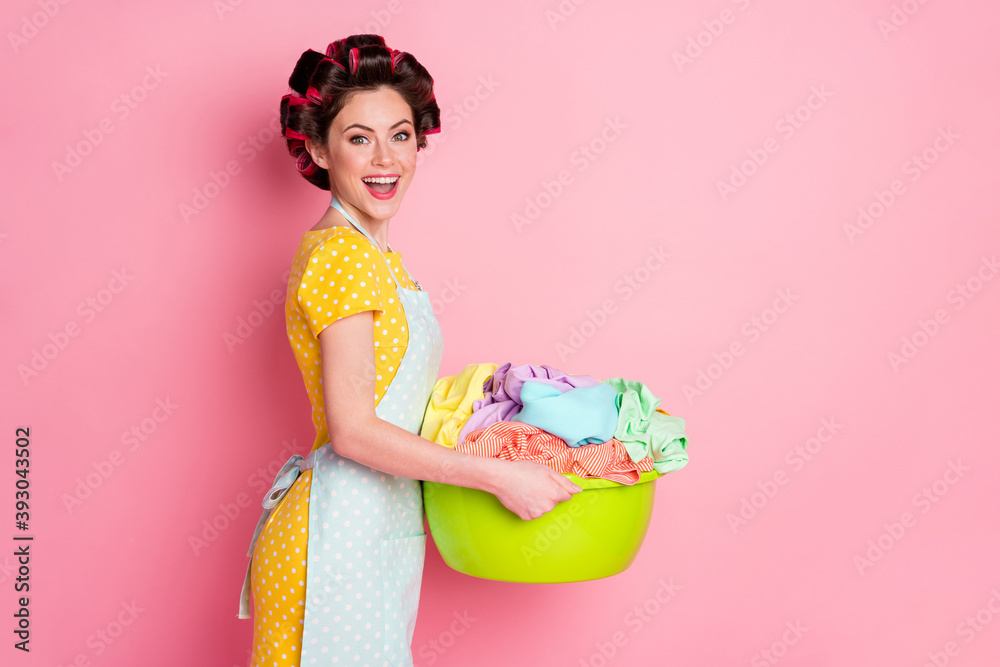 Profile side photo of positive girl hold basin dirty clothes laundry wear yellow skirt isolated on pastel color background Profile side photo of positive girl hold basin dirty clothes laundry wear yellow skirt isolated on pastel color background