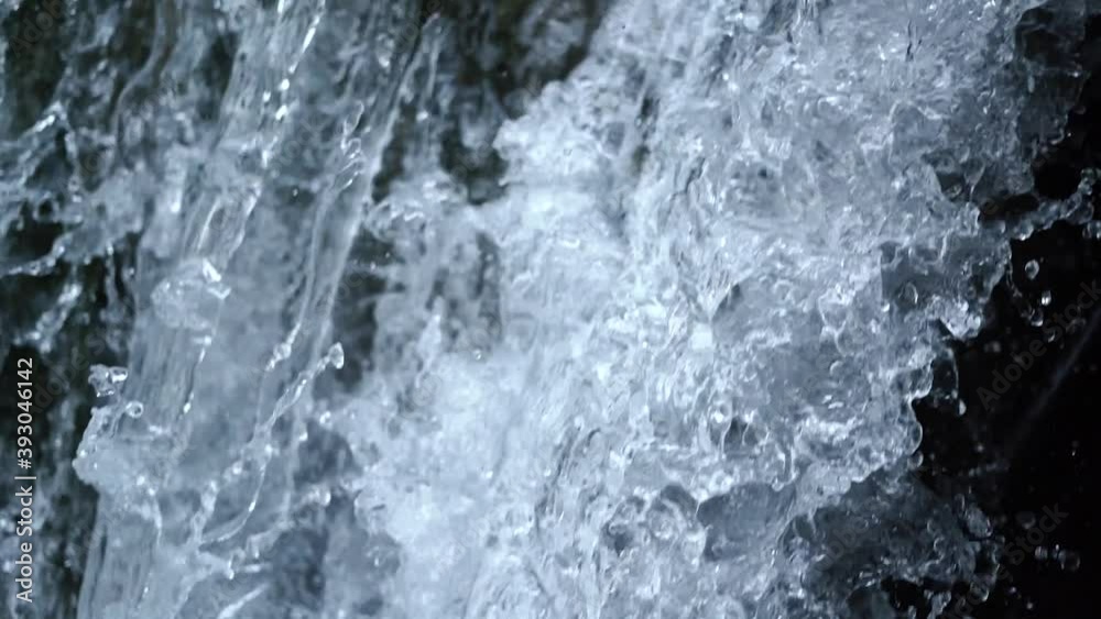 Water with bright sunlight reflections of grey and white colours falls down over dark hill in local national nature reserve on sunny summer day slow motion closeup. Water with bright sunlight reflections of grey and white colours falls down over dark hill in local national nature reserve on sunny summer day slow motion closeup.