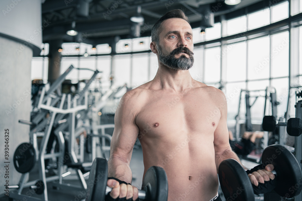 Training in gym, Handsome man with a mustache, do muscle building exercises using dumbbells, focusing on lifting and sit-ups in a fitness sport