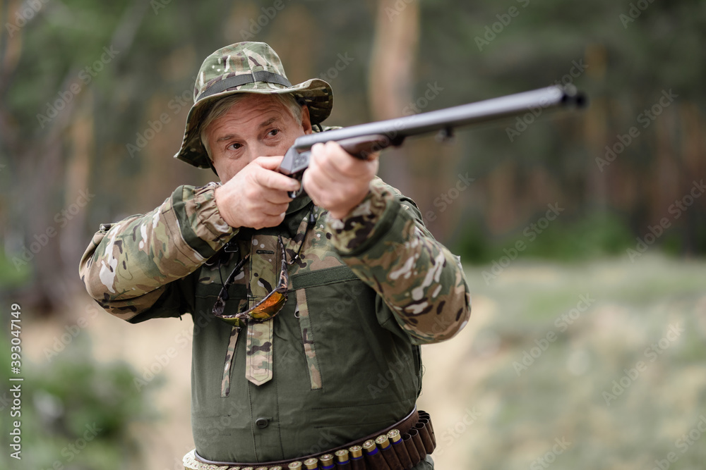 Fototapeta premium Hunting Season Senior Man is Aiming with Rifle.