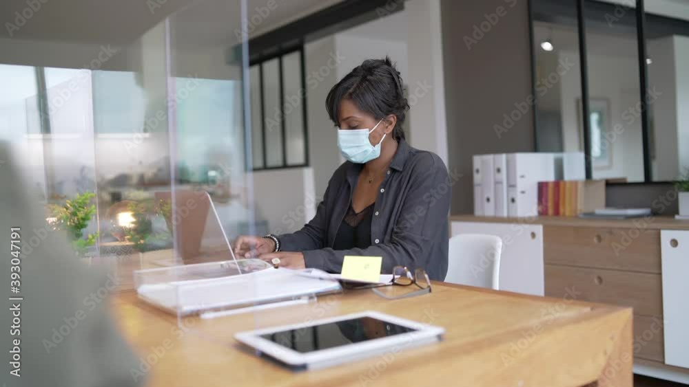 Office worker wearing surgical face mask in open space area Office worker wearing surgical face mask in open space area