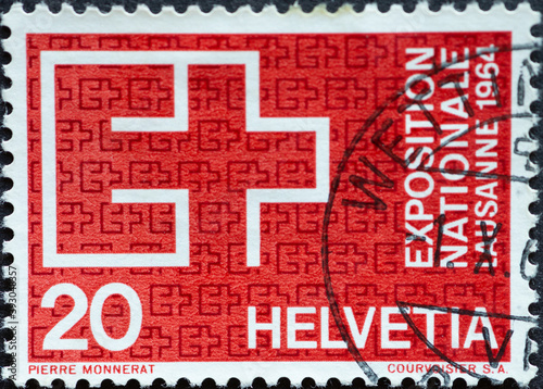 Switzerland - Circa 1963 : a postage stamp printed in the swiss showing the expo symbol text: Exposition national lausanne 1964 | red