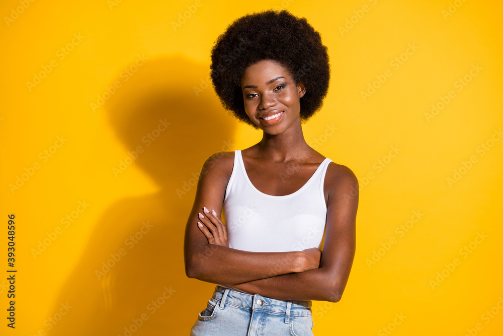 Photo of lady crossed arms look camera self-assured toothy smile wear white tank top isolated yellow color background Photo of lady crossed arms look camera self-assured toothy smile wear white tank top isolated yellow color background