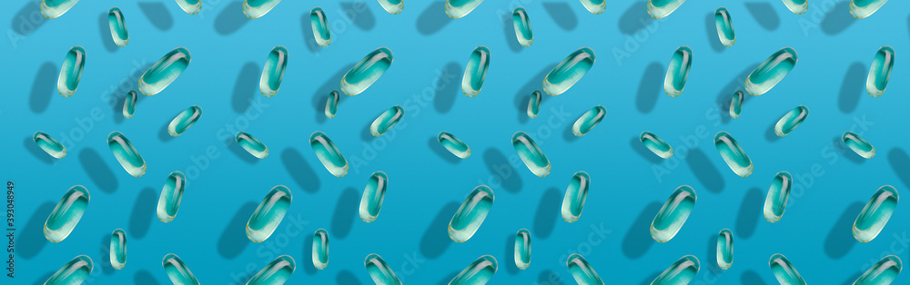 Banner with falling transparent fish oil pills on different planes against a blue uniform background. Vitamins and pills. Banner with falling transparent fish oil pills on different planes against a blue uniform background. Vitamins and pills.