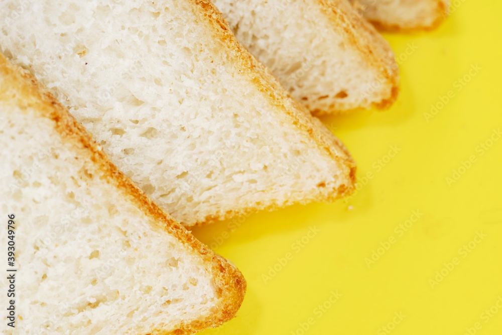 Sliced white bread on yellow background, top view