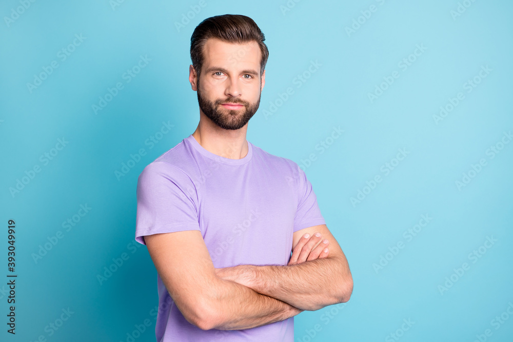 Photo of young attractive man confident smart macho folded hands isolated over blue color background Photo of young attractive man confident smart macho folded hands isolated over blue color background