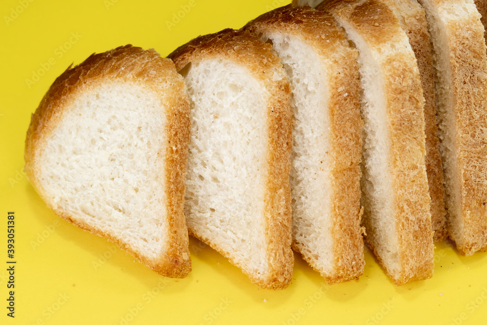 Sliced white bread on yellow background, top view Sliced white bread on yellow background, top view