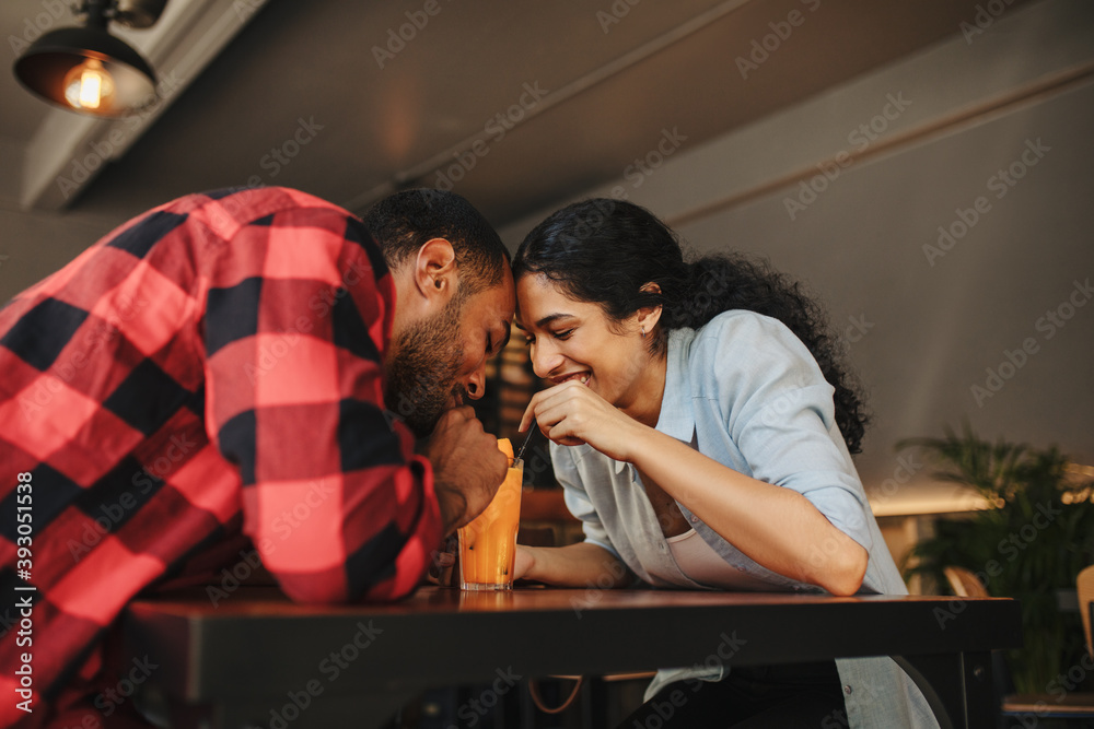 Obraz premium Loving couple having juice from same glass