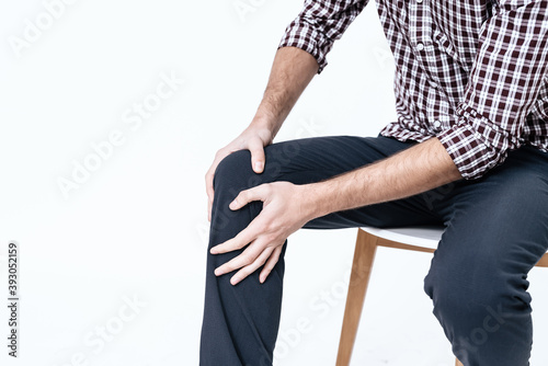A man holds on to his knees and does a massage. 