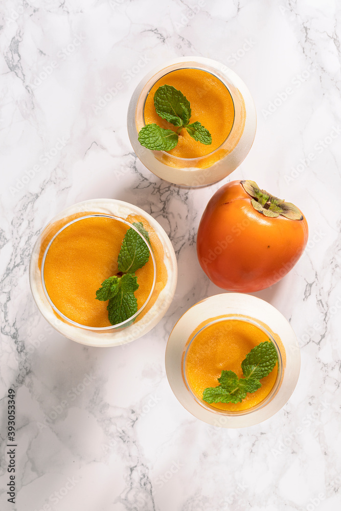 Three glasses with persimmon mousse dessert. Three glasses with persimmon mousse dessert.