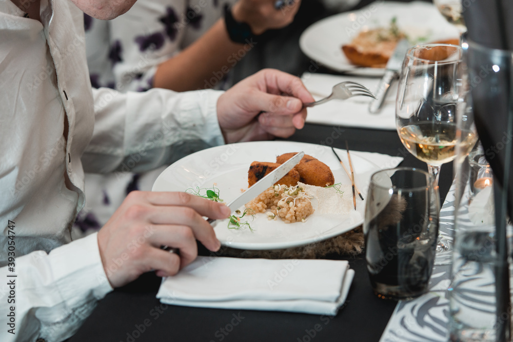 man eating juicy meat cutlets with a crisp on a ceramic plate with rice man eating juicy meat cutlets with a crisp on a ceramic plate with rice
