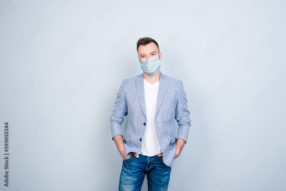 Photo portrait of guy with hands in pockets wearing blue face mask isolated on grey colored background Photo portrait of guy with hands in pockets wearing blue face mask isolated on grey colored background