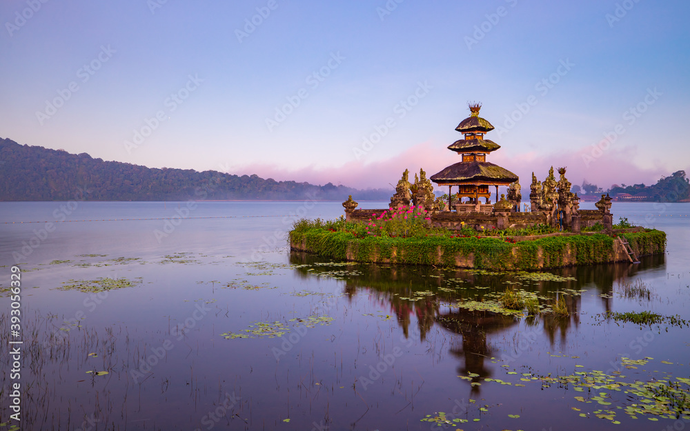 Pura Ulun Danu Bratan temple. Balinese landmark. Water reflection. Foreground with tree branches. Bratan lake, Bedugul, Bali, Indonesia Pura Ulun Danu Bratan temple. Balinese landmark. Water reflection. Foreground with tree branches. Bratan lake, Bedugul, Bali, Indonesia