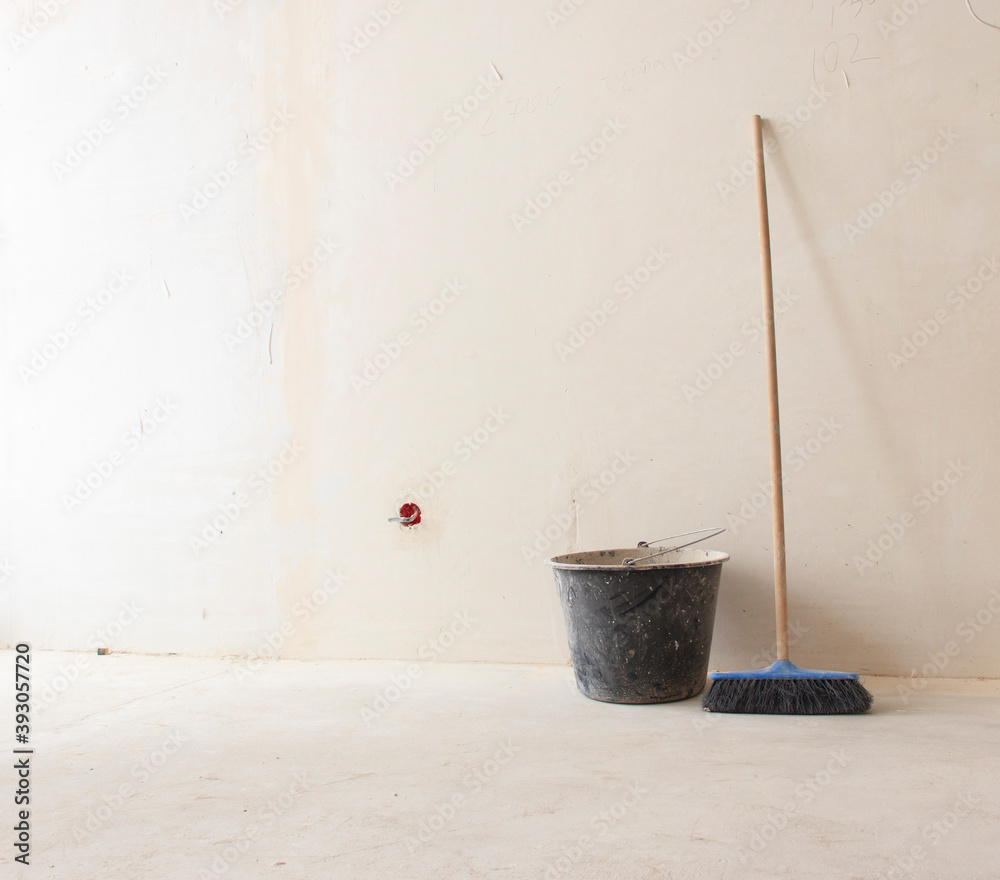 Ladder and bucket on a white background wall with copy space. Background of the concept of the object under construction. Ladder and bucket on a white background wall with copy space. Background of the concept of the object under construction.