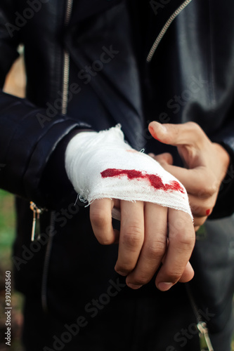 Fototapeta Man with bandage with blood on the knuckles, natural background