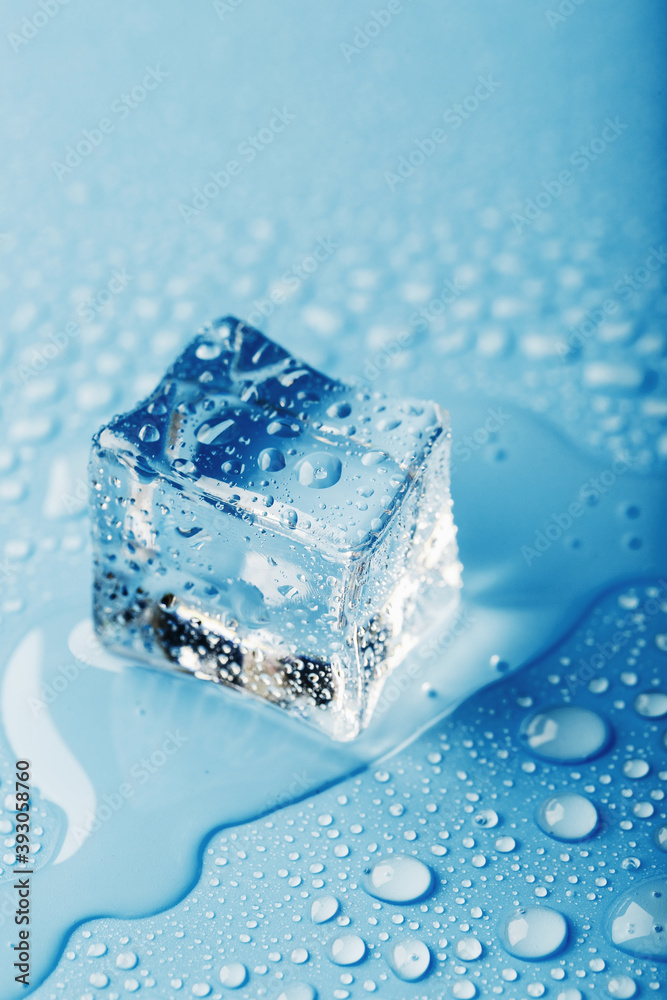 Close-up ice cubes with melt water drops scattered on a blue background.
