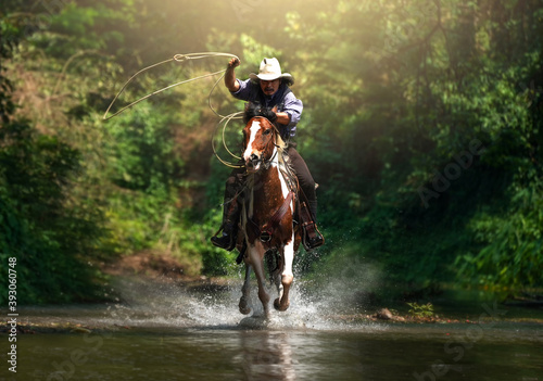 Leinwand Poster Western cowboy riding in the water