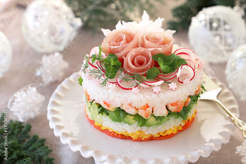 Christmas layered salad with salmon, avocado, shrimp, and vinegared rice on holiday decoration table. ケーキ寿司 クリスマス