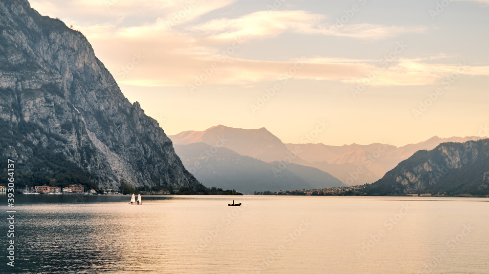 Panorama of Lake Como with small sailing boats and Swiss alps in the background