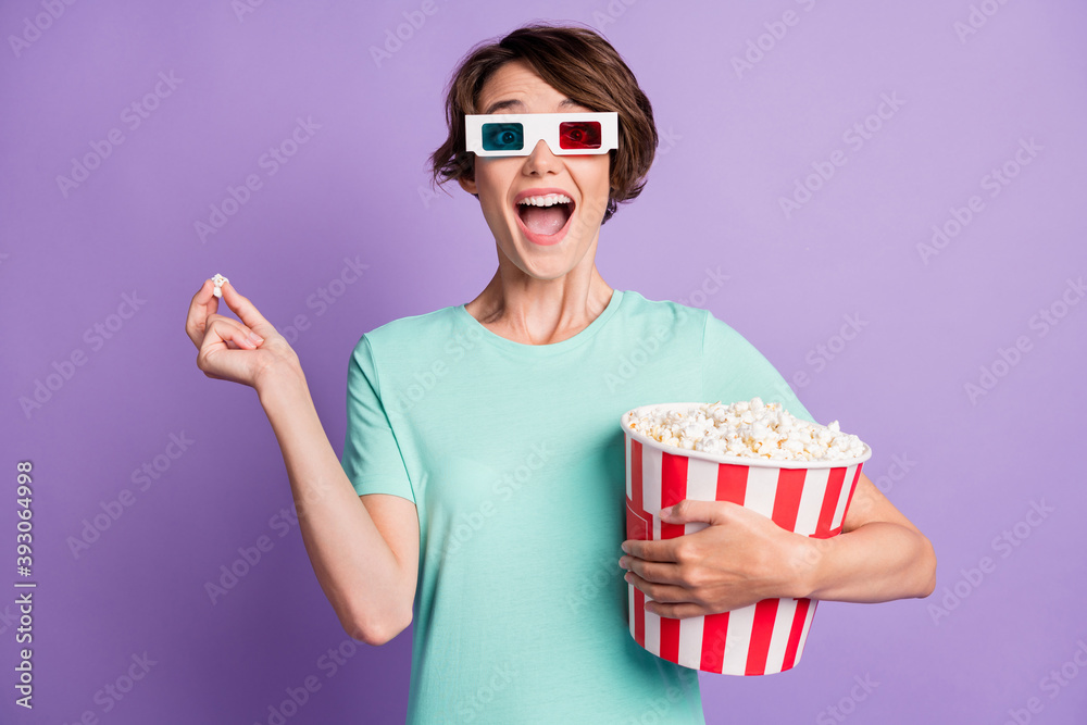 Photo of charming young woman dressed casual turquoise clothes 3d cinema eyeglasses eating popcorn isolated violet color background