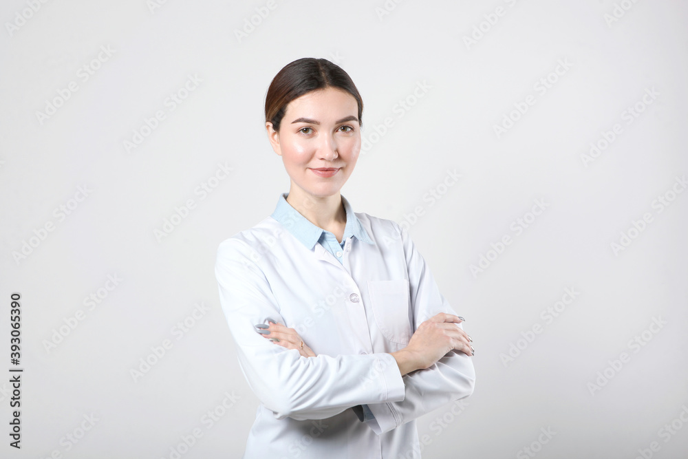 Young woman doctor on light background with place to place text Young woman doctor on light background with place to place text