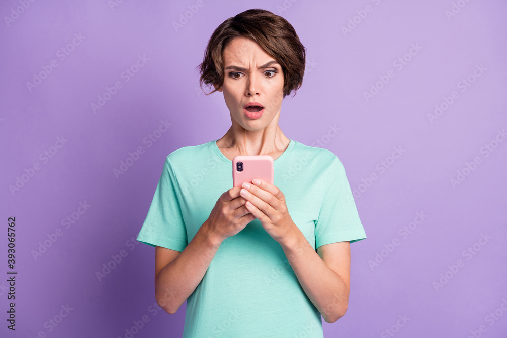 Photo of attractive angry irritated lady staring phone open mouth wear stylish turquoise isolated on violet color background Photo of attractive angry irritated lady staring phone open mouth wear stylish turquoise isolated on violet color background