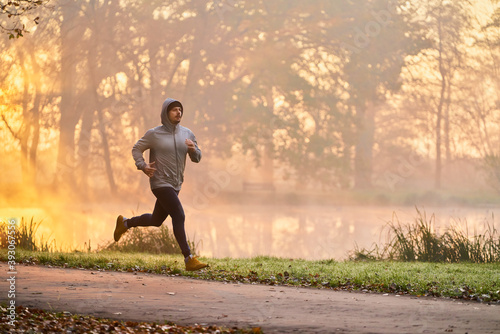 Man jogging in the park during autumn morning photo