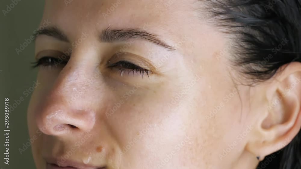 close-up of eyes of young brunette in bathroom who looks at camera, then closes her eyes and winces at spray of water from shower head close-up of eyes of young brunette in bathroom who looks at camera, then closes her eyes and winces at spray of water from shower head