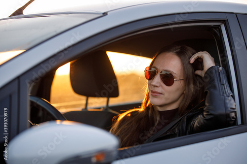 Young woman driving rented car in the evening