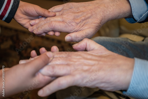 Fototapeta Naklejka Na Ścianę i Meble -  Close-up of grandson holding grandfather hands.