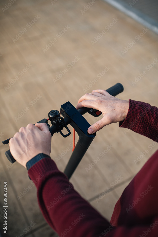 Naklejka premium electric skate with hands touching the buttons. Alternative transport