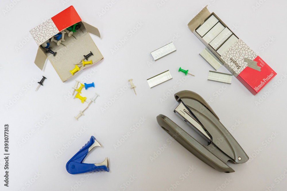Fototapeta premium Office supplies on a white background. Stapler, staples, pioneers
